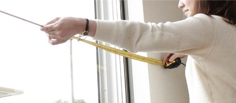 窓を採寸する女性